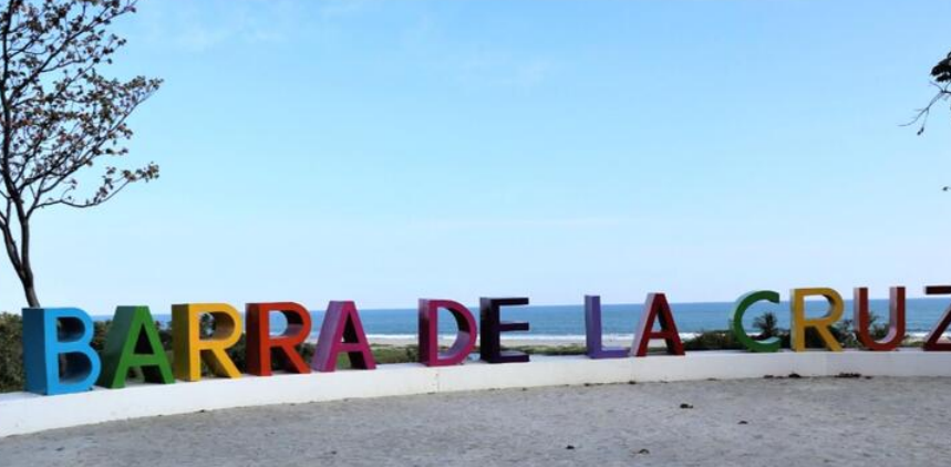 Fototeca Letras monumentales de colores con el nombre «Barra de la Cruz» junto al camino de acceso.