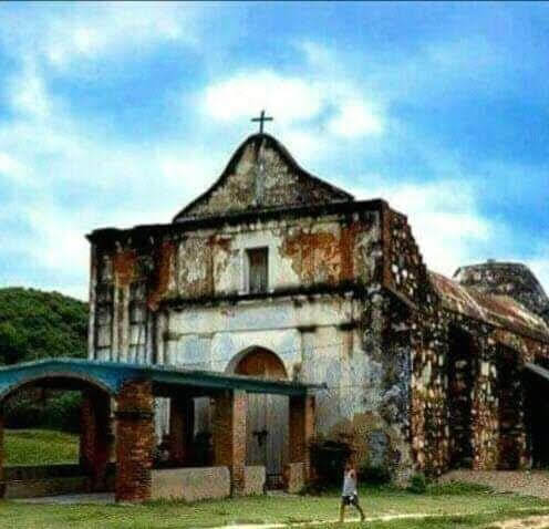 Fototeca Iglesia colonial en ruinas con una cruz sobre la fachada.