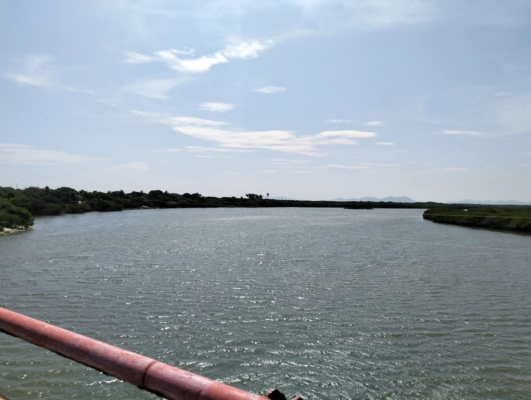 Fototeca Laguna de la zona mareña bajo cielo nublado, vista desde un barandal.