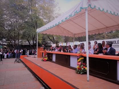 Presídium bajo una carpa con mesa larga cubierta de tela roja