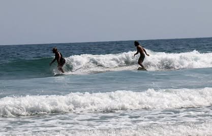 Memoria de campo 2011–2026 Surfista sobre una ola que rompe cerca de la orilla