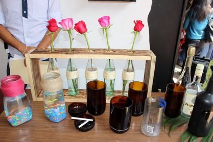Prototipo hecho con botellas recicladas y flores sobre una base de madera