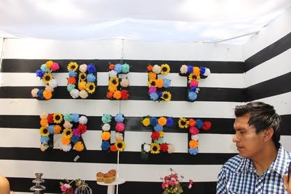 Stand con pared de franjas blancas y negras y productos de colores