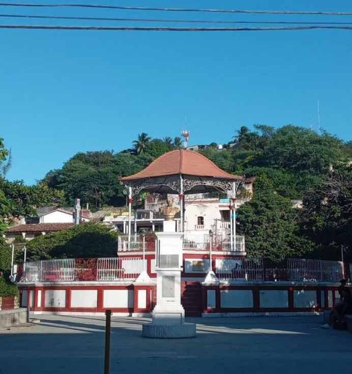 Fototeca Kiosco de la plaza principal de Santo Domingo Tehuantepec rodeado de árboles.