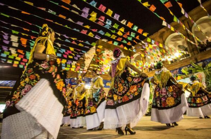 Fototeca Danza tradicional bajo papel picado, con mujeres en traje bordado del Istmo.