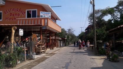 Mazunte y Punta Cometa: infraestructura turística de un Pueblo Mágico Calle de Mazunte con negocios de madera de dos pisos y palmeras