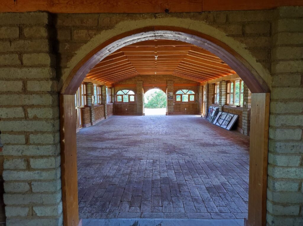 San Pablo Etla: acuerdos para fortalecer un proyecto ecoturístico Interior de una cabaña de piedra con techo de madera y puerta en arco