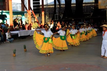 Grupo de bailarinas con faldas amarillas danzando en una explanada