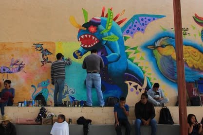 Mural de colores con una figura fantástica, frente al que pasan varias personas