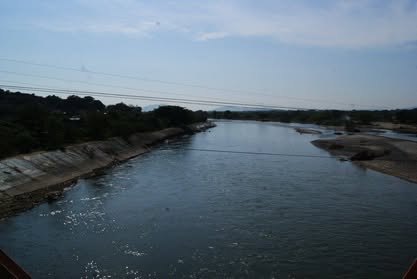 Río de cauce ancho con orillas de arena bajo un cielo de atardecer