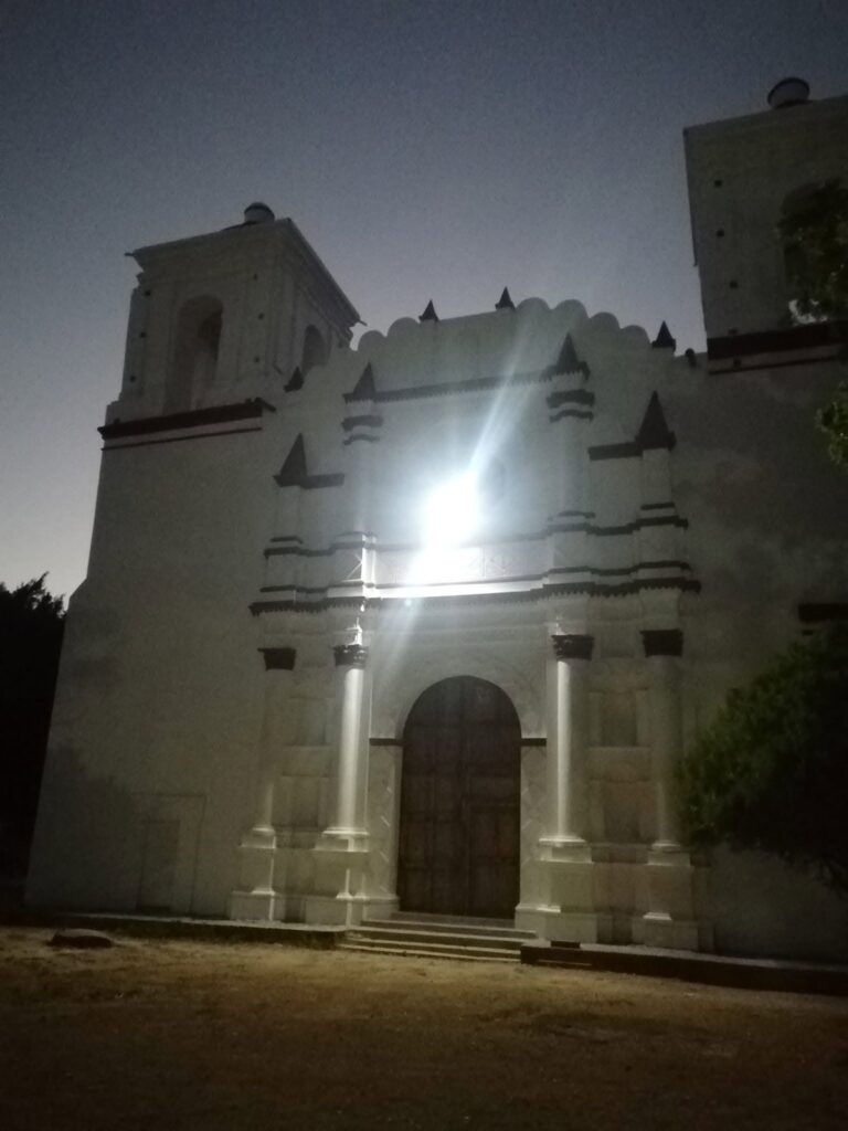 Fachada blanca de un templo antiguo iluminada de noche