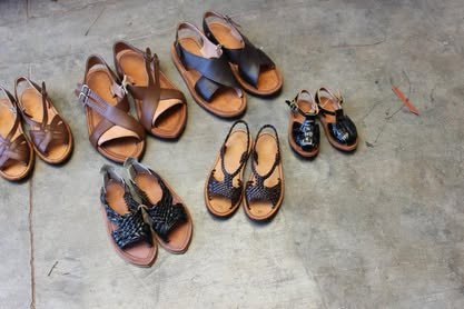 Varios pares de huaraches de piel acomodados sobre el piso